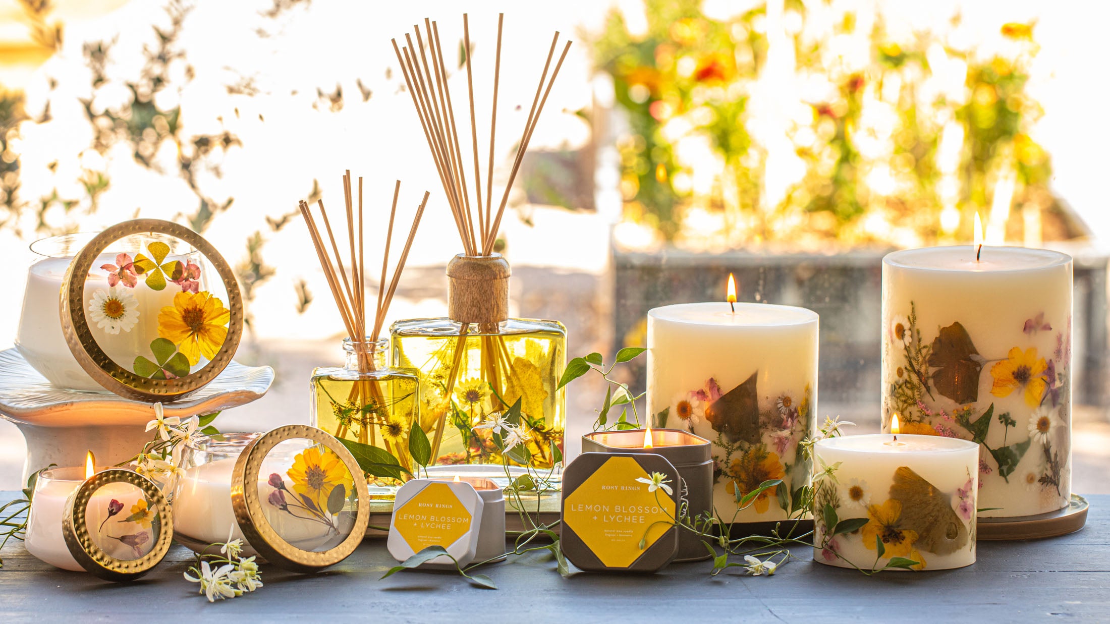 A display of scented candles with floral designs, essential oil bottles, a cozy ambiance featuring soft natural light.